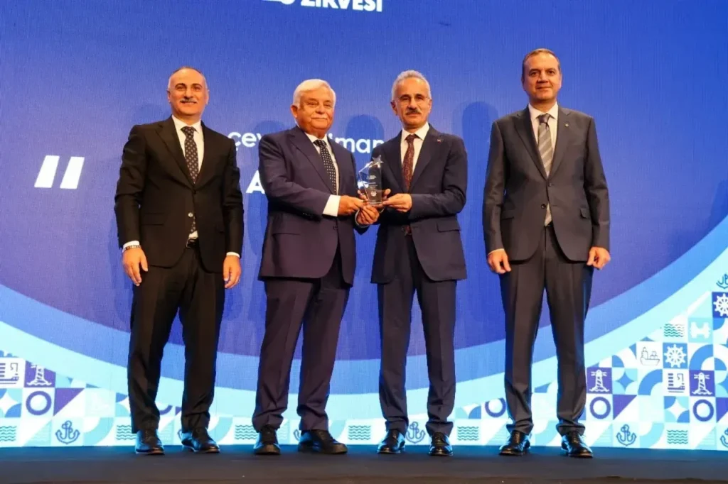 Asyaport Yönetim Kurulu Başkanı Ahmet Soyuer’e, “En Çevreci Liman Tesisi” ödülü Ulaştırma Bakanı tarafından takdim edilirken çekilen tören fotoğrafı.